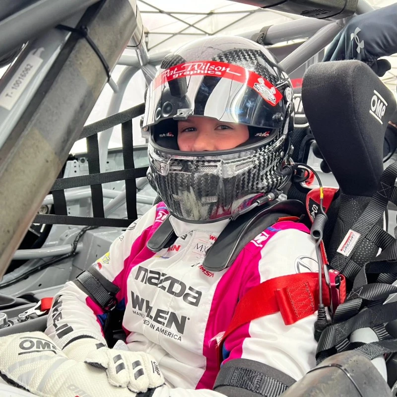 image of racecar driver Ashlyn Speed wearing helmet and racing gear with Mazda and Whelen logos on chest