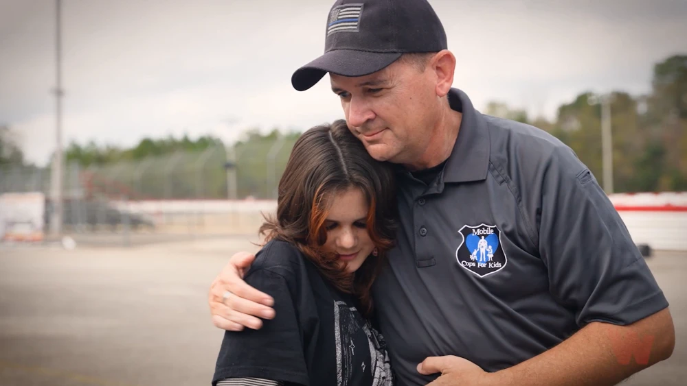image of 2021 Whelen Everyday Champion Sergeant Jeremy March comforting a youngster with hug
