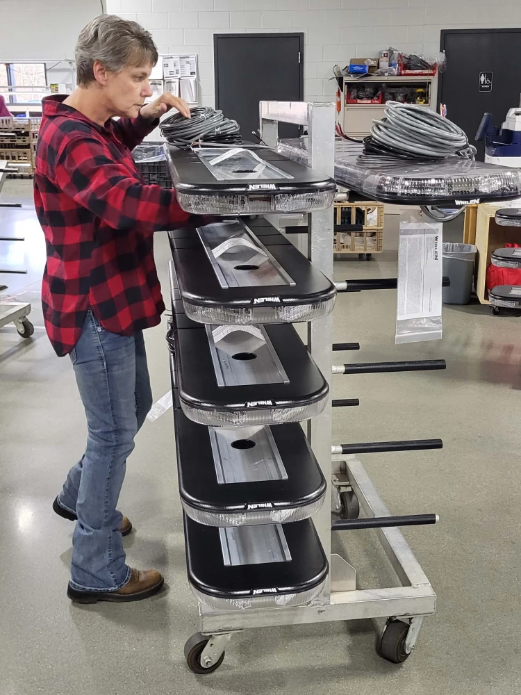 Whelen quality-control inspector checking lightbars in Whelen manufacturing plant
