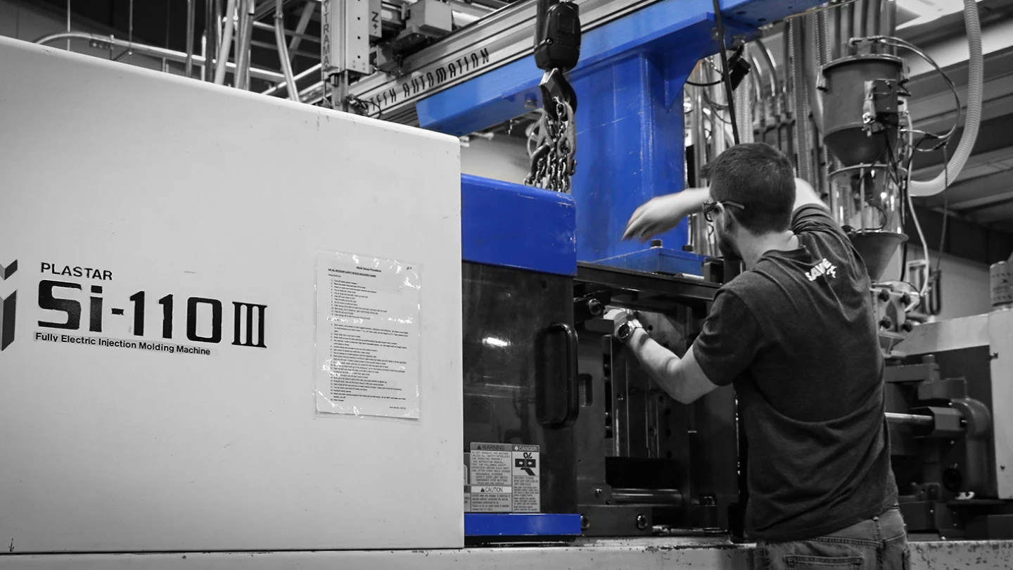 image of Whelen Engineering employee operating injection-molding machine at Whelen manufacturing facility for emergency lighting