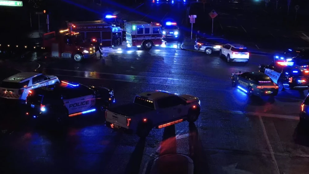 image of police and fire emergency vehicles with falshing lights at scene of nighttime incident