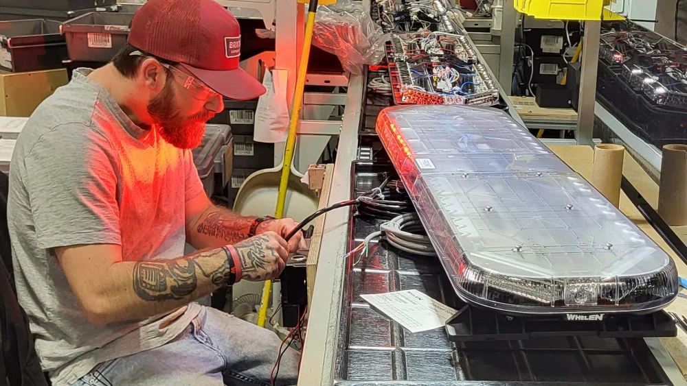 Whelen employee working on lightbar in Whelen manufacturing facility