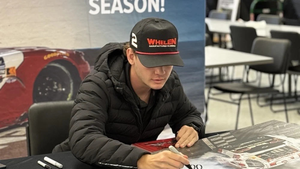 Jesse Love poses with his 2025 NASCAR Xfinity Series championship trophy during his visit to Connecticut.