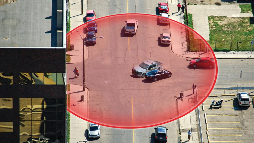 aerial view of emergency vehicle at scene of traffic accident and red circle to depict the Whelen Cloud Platform's geofencing capabilities
