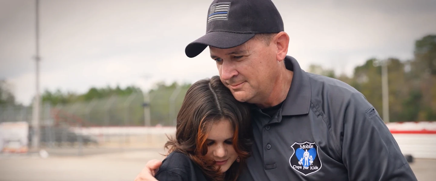 image of 2021 Whelen Everyday Champion Sergeant Jeremy March comforting a youngster with hug