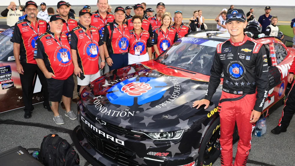 image of NASCAR driver Jesse Love and his crew alongside the Whelen #2 Chevy Camaro displaying National Fallen Firefighters Foundation (NFFF) commemorative paint scheme