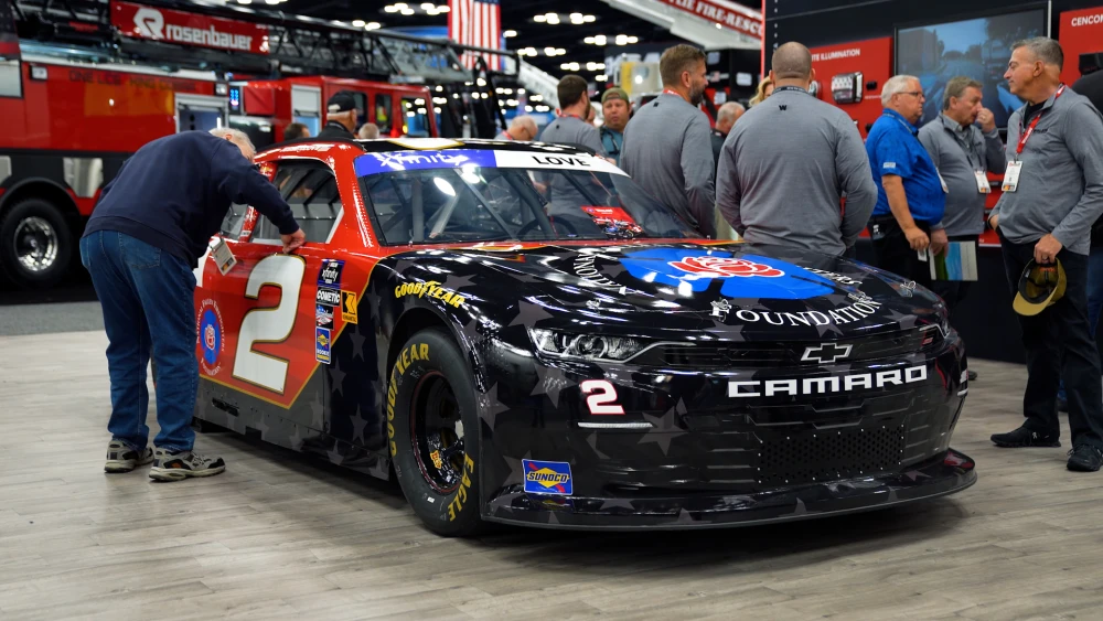 image of RCR's No. 2 Whelen Chevy Camaro with special National Fallen Firefighters Foundation (NFFF) paint scheme on display at Whelen Engineering booth during at FDIC 2024 conference